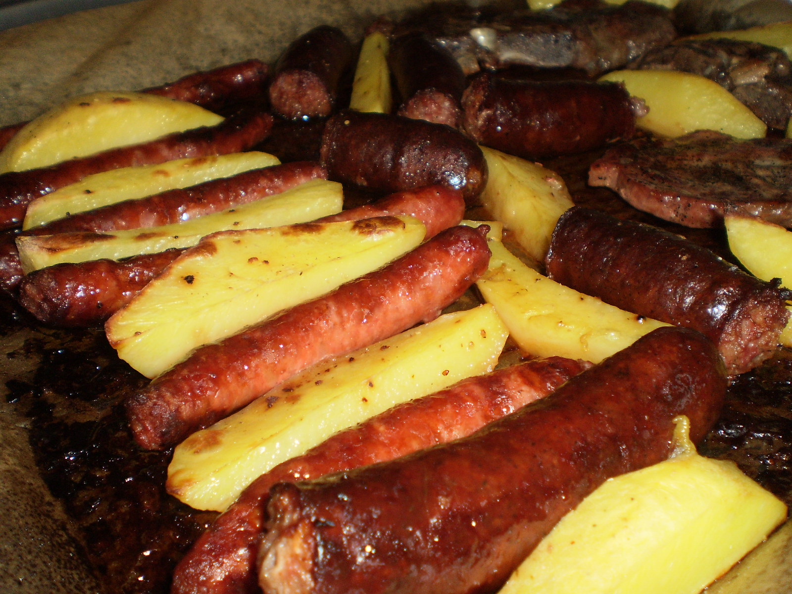 Carnati, ceafa si cartofi la cuptor pe pat de varza acra